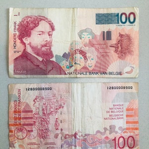May include: Two sides of a 100 Belgian Francs banknote. The front features a portrait of James Ensor and various mask illustrations. The back shows a detailed illustration of a parade and the text "Banque Nationale de Belgique".