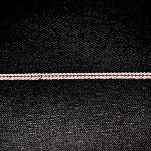 May include: Black denim fabric with a single red and white stitched line across the middle.