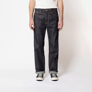May include: A pair of dark blue denim jeans with a straight leg fit. The jeans have a classic five-pocket design and a button fly.