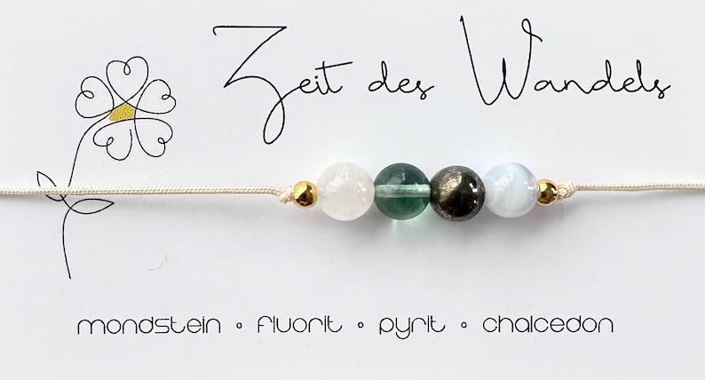 May include: A delicate bracelet featuring four gemstone beads: moonstone, fluorite, pyrite, and chalcedony. The beads are strung on a beige cord, accented with gold-colored beads. The card reads "Zeit des Wandels" and lists the gemstones.