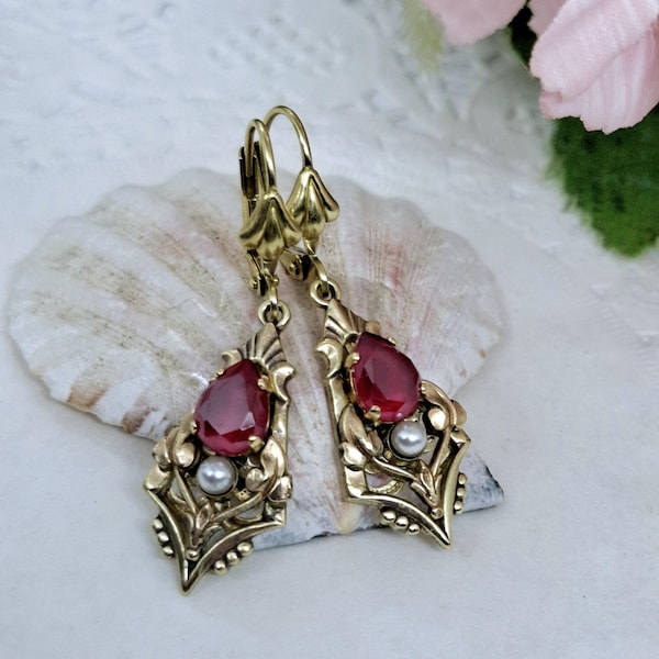 Pendientes elegantes de estilo victoriano con cristales rojos colgantes.
