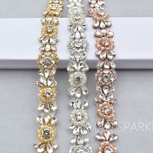 May include: Three beaded trims with floral designs in gold, silver, and rose gold. Each trim features a repeating pattern of rhinestones and pearls.