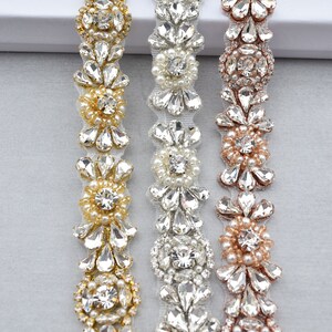 May include: Three beaded trims with different colored metal accents. The trims feature clear rhinestones and pearls in a floral design.