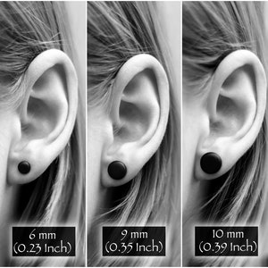 May include: Five black ear gauges of different sizes, shown in a person's ear. The gauges are 4 mm (0.16 inch), 6 mm (0.23 inch), 9 mm (0.35 inch), 10 mm (0.39 inch), and 12 mm (0.47 inch).