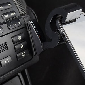 May include: A black car phone mount with the word "GRAVITY" printed on it. A smartphone is attached to the mount.