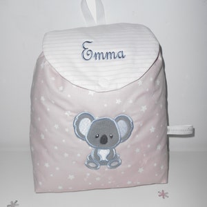 K&ouml;nnte beinhalten: Ein rosa Stoffrucksack mit wei&szlig;en Sternen und einem gestickten grauen Koala auf der Vorderseite. Der Rucksack hat eine wei&szlig;e Klappe mit rosa Streifen und den Namen "Emma" darauf gestickt.