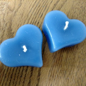 May include: Two blue heart-shaped candles with white wicks.