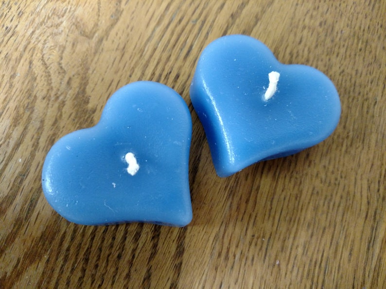 May include: Two blue heart-shaped candles with white wicks.