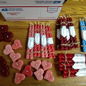 May include: Assortment of heart-shaped and twisted candles in red, pink, and blue. The candles are packaged in bundles and tied with twine. The image also includes a USPS Priority Mail box.