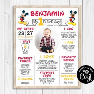 May include: A personalized first birthday poster with a photo of a baby. The poster includes the name "Benjamin", measurements of 28 inches and 27 pounds, and favorite things like foods, toys, and songs. Mickey Mouse graphics are at the top.
