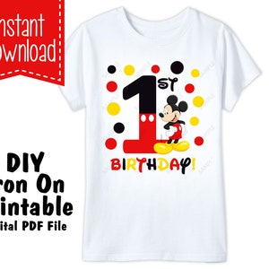 Op de afbeelding: Strijkbaar printbaar ontwerp met Mickey Mouse en het nummer &eacute;&eacute;n, omringd door rode en gele stippen. Het ontwerp luidt "1e Verjaardag!" in zwarte tekst.