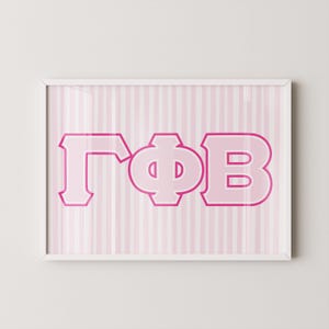 Peut inclure: Impression encadrée avec les lettres grecques ΓΦΒ en rose clair. Les lettres sont soulignées en rose plus foncé sur un fond rayé rose et blanc. L'impression est encadrée dans un cadre blanc.