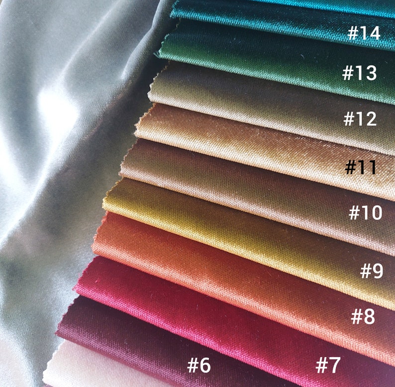 May include: A swatch card of 14 different velvet fabric samples in various shades of green, brown, orange, red, and beige. The swatches are numbered 6 through 14.