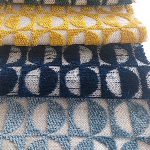 May include: Four fabric swatches with a geometric pattern of half circles. The swatches are in shades of green, yellow, blue, and light blue.