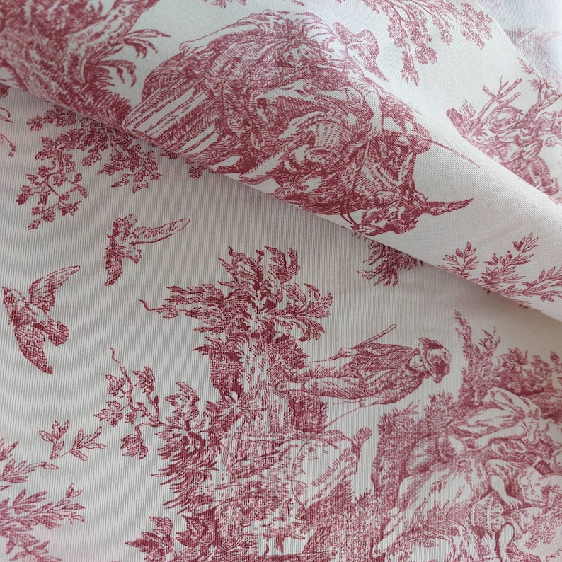 May include: Red and white toile fabric featuring a repeating pattern of birds, trees, and figures. The fabric has a subtle texture and a vintage aesthetic.