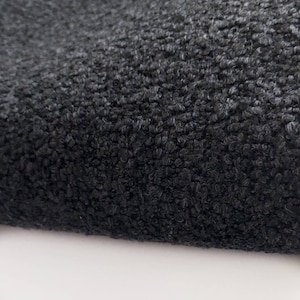 May include: Close-up of a black, textured fabric with a fuzzy, soft surface.