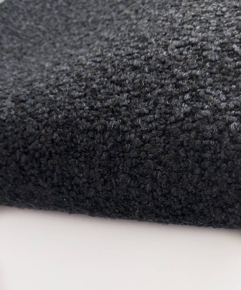 May include: Close-up of a black, textured fabric with a fuzzy, soft surface.