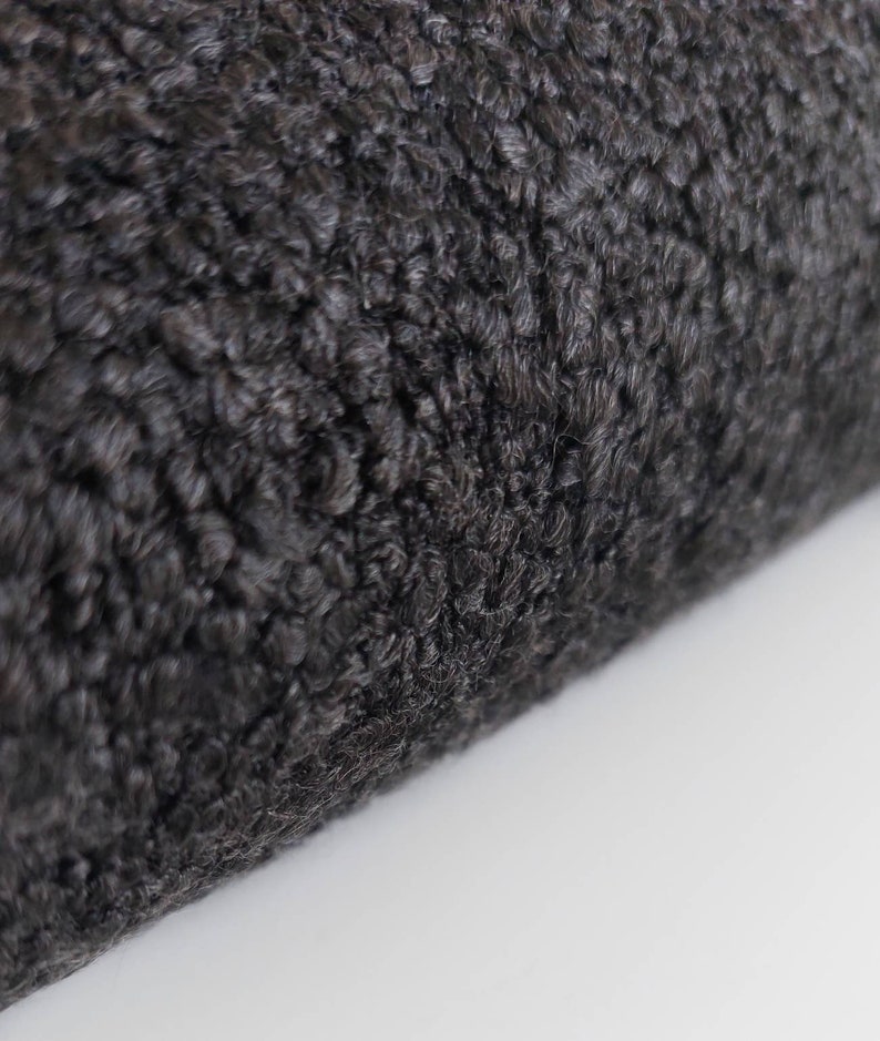 May include: Close-up of a black faux fur fabric with a soft, fluffy texture.