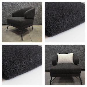May include: A black armchair with a plush, fuzzy fabric upholstery. The chair has a curved back and a wide, comfortable seat. The chair is supported by a black metal frame with thin legs.