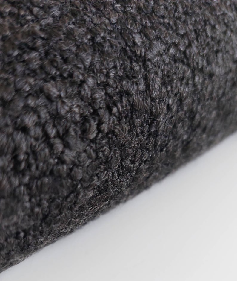 May include: Close-up of a black faux fur fabric with a soft, fluffy texture.