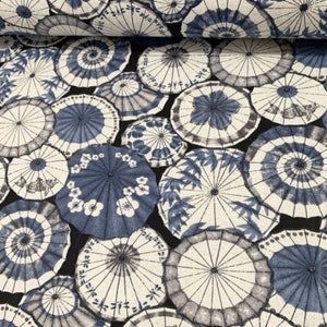 May include: Black fabric with a repeating pattern of blue and white Japanese umbrellas. The umbrellas are various sizes and have a traditional design.