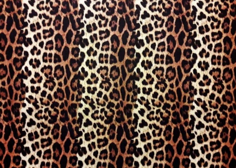 May include: A brown, black, and white leopard print fabric with a symmetrical pattern.