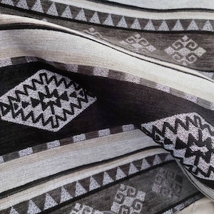 May include: Black and white patterned fabric with a geometric design. The fabric has a textured surface and a woven look.