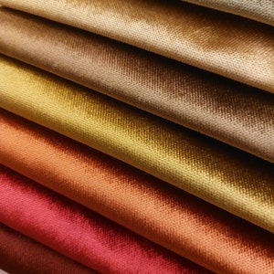 May include: A close-up of a stack of fabric swatches in various shades of brown, orange, and red. The fabric has a soft, velvety texture.