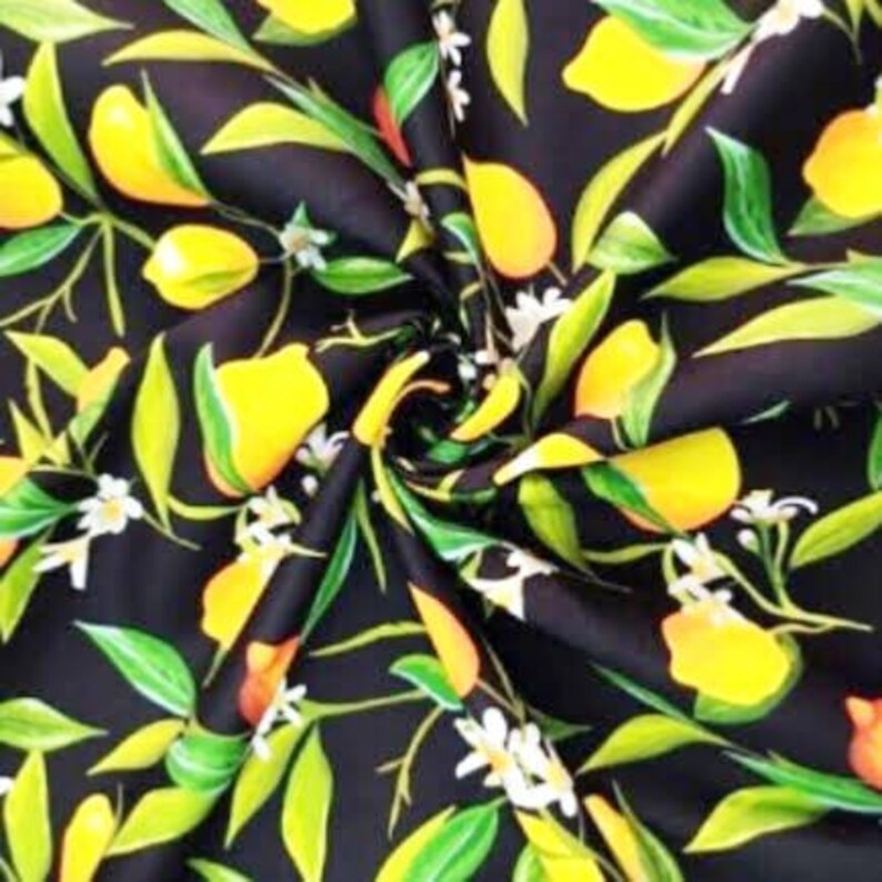K&ouml;nnte beinhalten: Schwarzer Stoff mit einem Zitronenmuster. Das Design zeigt leuchtend gelbe Zitronen, gr&uuml;ne Bl&auml;tter und kleine wei&szlig;e Bl&uuml;ten. Der Stoff ist eng gewirbelt und zeigt den detaillierten Druck.