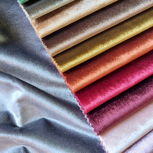May include: A collection of fabric swatches in various shades of brown, red, orange, yellow, and green. The swatches are arranged in a fan shape, with the lightest colors at the top and the darkest colors at the bottom.