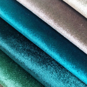 May include: Close-up of four fabric swatches in shades of green and blue. The fabric has a soft, velvety texture.