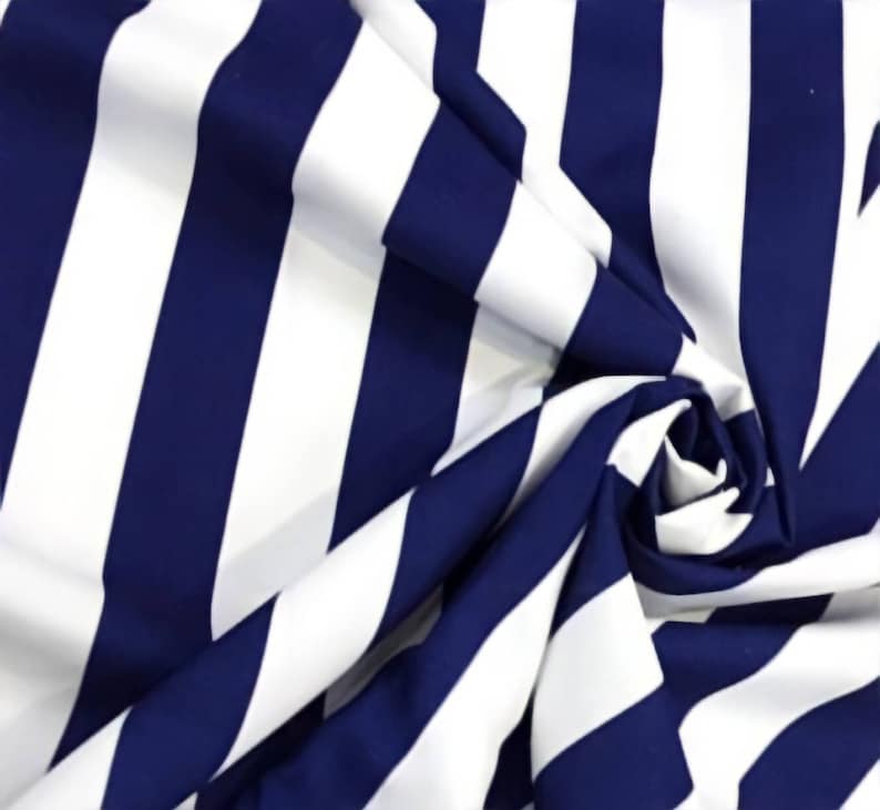 May include: White and navy blue striped fabric with a diagonal pattern. The fabric is folded and draped, showing the texture and color of the material.