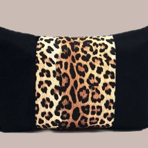 May include: Black and brown leopard print throw pillow with black fabric on the sides.