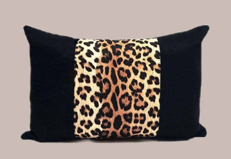 May include: Black and brown leopard print throw pillow with black fabric on the sides.