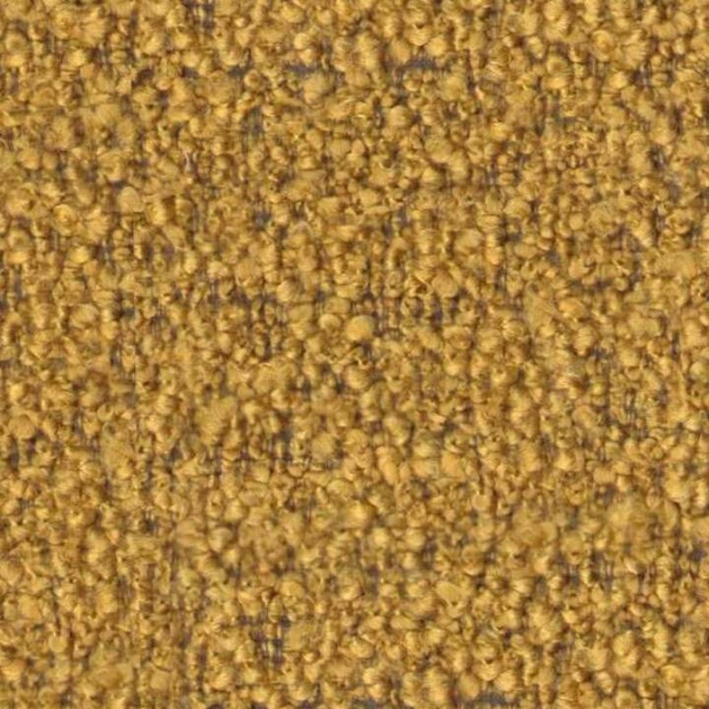 Op de afbeelding: Een close-up van een textuurdoek met een gele en bruine kleurstelling. De stof heeft een pluche, bijna pluche textuur.
