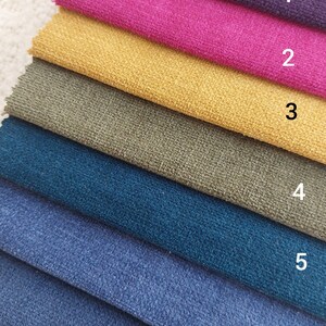 May include: A stack of seven fabric swatches in different colors, including purple, pink, yellow, green, teal, blue, and light blue. The swatches are numbered 1 through 7.