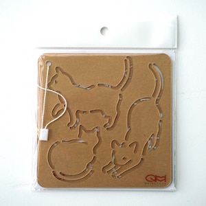 May include: A brown cardboard stencil featuring four cat outlines. The stencil is packaged in a clear plastic bag with a white string attached to the top.