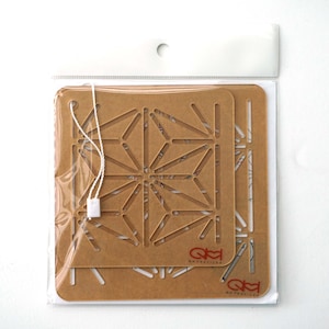 May include: Two brown cardboard stencils with a geometric pattern. The stencils are packaged in a clear plastic bag with a white string.