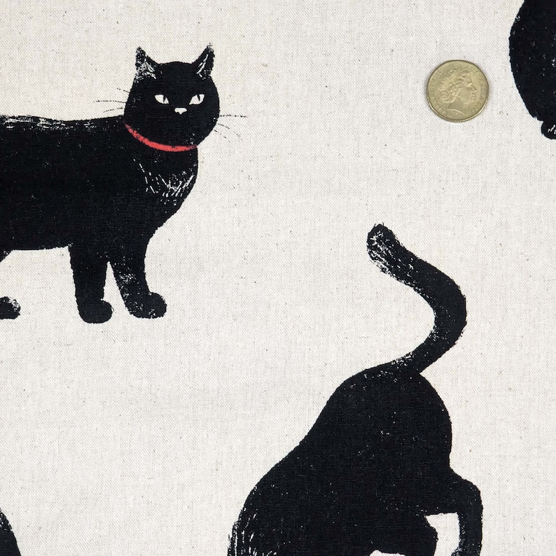May include: Black and white fabric with a repeating pattern of black cats. The cats are in various poses, some are sitting, some are standing, and some are walking. The fabric has a subtle texture.
