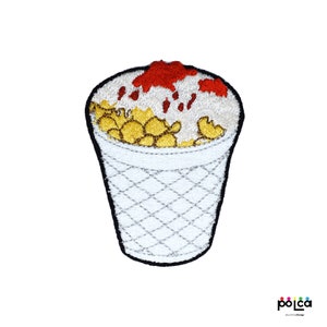 May include: Embroidered iron-on patch of a white paper cup filled with yellow popcorn, topped with white frosting and red sauce.