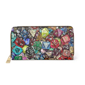 Könnte beinhalten: Eine farbenfrohe Reißverschluss-Geldbörse mit einem Muster aus Würfeln in verschiedenen Farben und Zahlen. Die Würfel sind in einem zufälligen Muster angeordnet und haben unterschiedliche Größen.