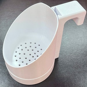 May include: White plastic strainer with a handle. The strainer has a round bowl with small holes and a handle that extends from the side of the bowl.