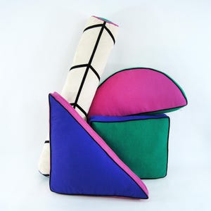 Peut inclure: Un ensemble de quatre coussins décoratifs de formes géométriques. Les coussins sont faits d'un tissu doux et moelleux et présentent une variété de couleurs, notamment le blanc, le noir, le rose, le bleu et le vert. Les coussins sont parfaits pour ajouter une touche de style et de confort à n'importe quelle pièce.