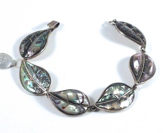 May include: A silver bracelet with a series of abalone shell leaf charms. The leaves are iridescent with shades of green, blue, and purple.
