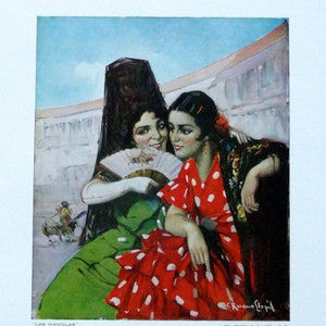 May include: Two women in traditional Spanish dress, one wearing a red dress with white polka dots and a black shawl, the other wearing a green dress with a black veil. They are standing in a bullfighting ring, with the text "Las Mandolas" at the bottom of the image.