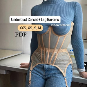 May include: A beige underbust corset with leg garters. The corset is made of a sheer mesh fabric and has a boned structure. The leg garters are attached to the corset with straps. The text "Underbust Corset + Leg Garters" and "XXS, XS, S, M" is visible on the image. The text "PDF" and "video tutorial" is also visible on the image.