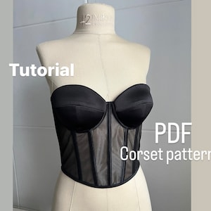 May include: A black strapless corset with a mesh panel in the front. The text "Tutorial" and "PDF Corset pattern" is visible in the image.