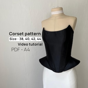 Può includere: Un corsetto nero senza spalline con orlo a baschina esposto su un manichino. Il testo sull'immagine recita: Corset pattern, Size - 38, 40, 42, 44, Video tutorial, PDF - A4. Il corsetto presenta cuciture verticali e un corpetto strutturato.