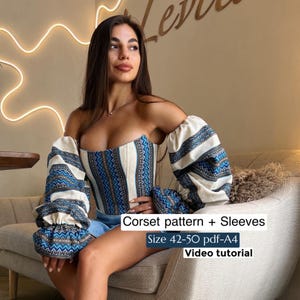 Può includere: Un corsetto color crema con dettagli a fantasia blu e bianca, abbinato a maniche coordinate. Il testo sull'immagine recita: "Corset pattern + Sleeves, Size 42-50 pdf-A4, Video tutorial."