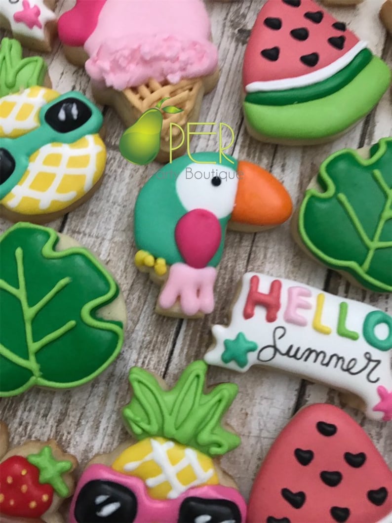 May include: Assortment of summer-themed cookies, including a toucan, watermelon slices, pineapple with sunglasses, and ice cream cone. The cookies are decorated with bright colors and the phrase "HELLO Summer".